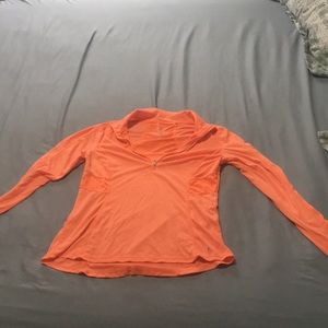 Light orange long sleeve top with holes on sleeve for thumbs